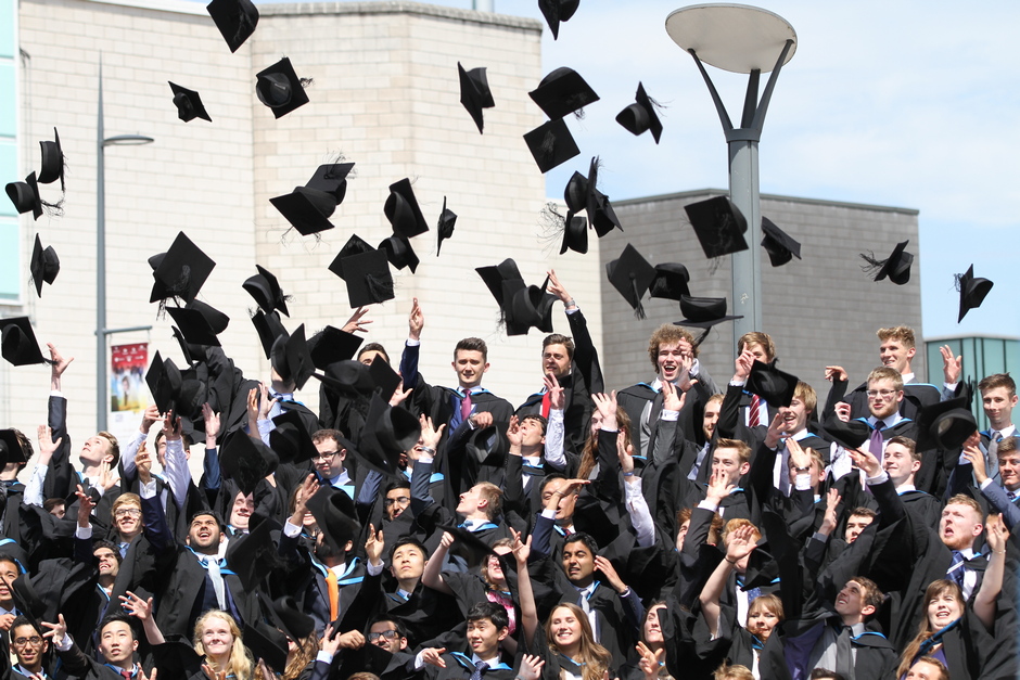 Graduates at graduation ceremony throwing caps