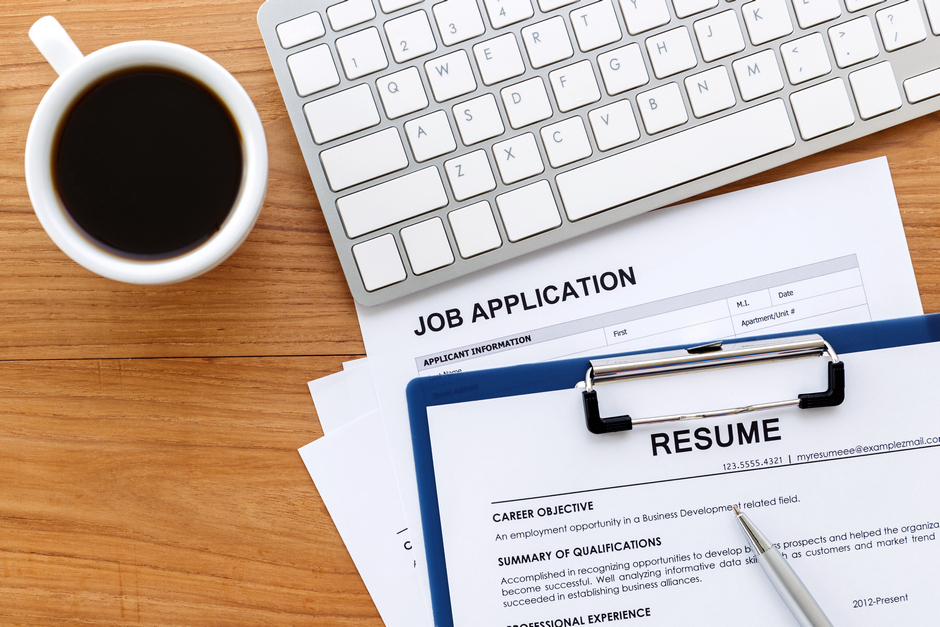 An image of a job application and CV on table next to coffee cup